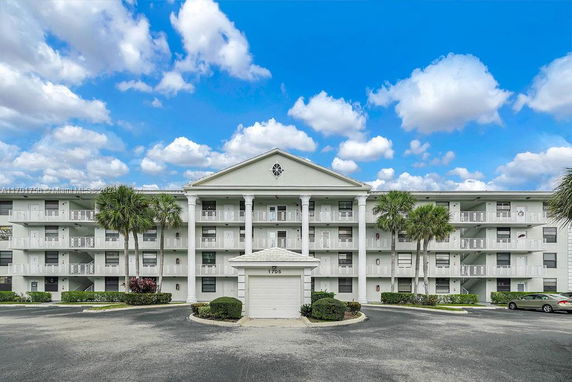 Front view of a multi-story apartment building with balconies and columns.