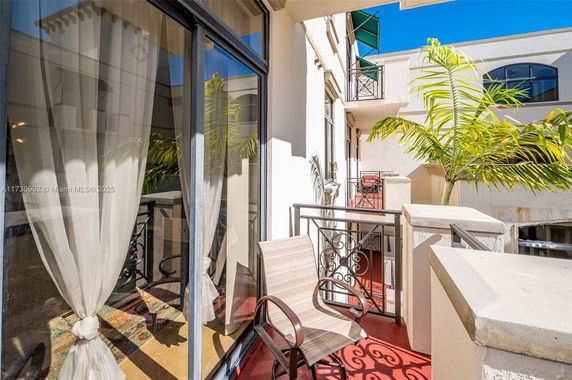 Balcony area with chairs overlooking surrounding residential structures.