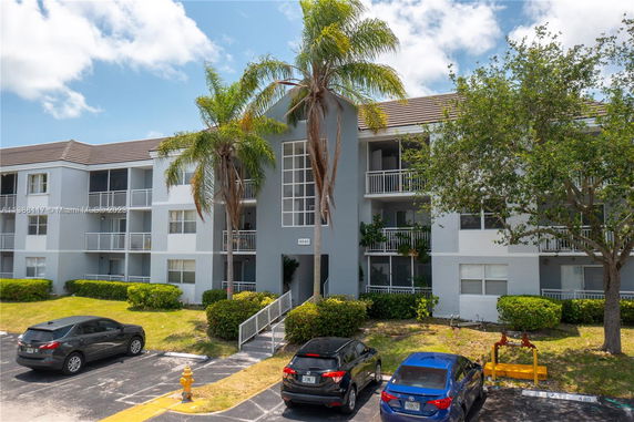 Front view of a multi-story apartment building with balconies.