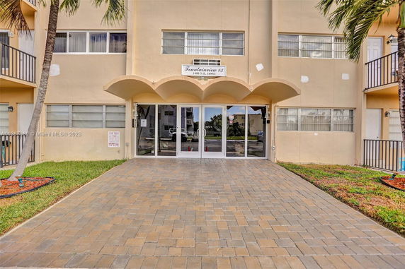Front entrance view of a multi-story building with a paved walkway.