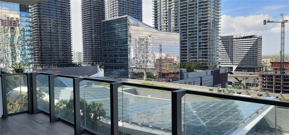 Panoramic view from a balcony showcasing multiple high-rise buildings in an urban area.