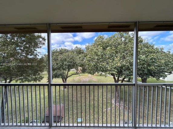 View of trees and grassy area seen from a balcony or deck.