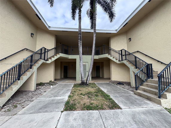 Front view of a two-story building with exterior staircases on both sides.