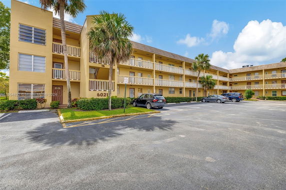 Front view of a three-story apartment building with balconies.