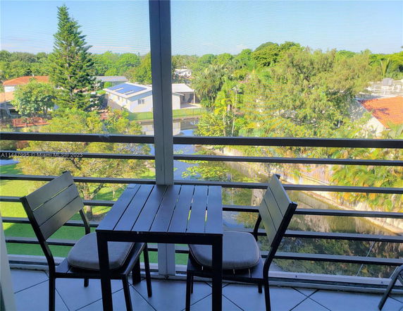 View from a balcony overlooking trees and houses.