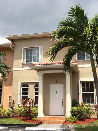Front view of a two-story house with columns and arched windows.