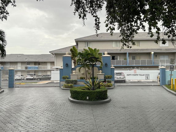 Front view of a gated residential complex with two-story buildings.