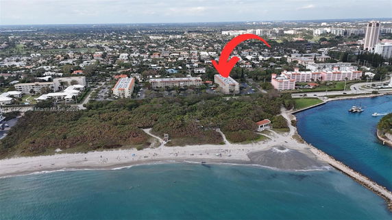 Aerial view of multiple residential buildings near a beach and a waterway.