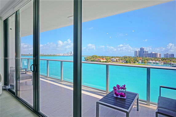 Panoramic view from a balcony overlooking a body of water and city skyline.