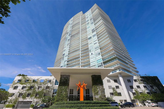 Front view of a modern high-rise building with glass balconies.