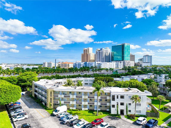 View of a residential area with low-rise buildings and a city skyline in the background.