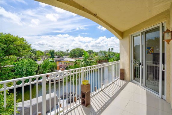 View from a balcony overlooking a canal and greenery.