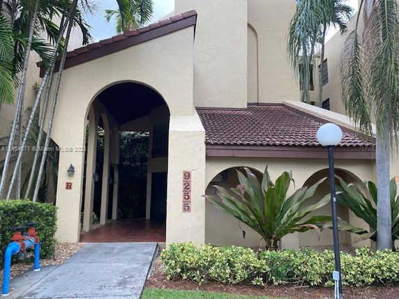 Front view of a multi-story building with arch entrances and a red-tiled roof.