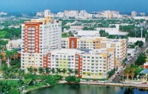 Aerial view of a multi-story residential complex with various buildings set against an urban backdrop.