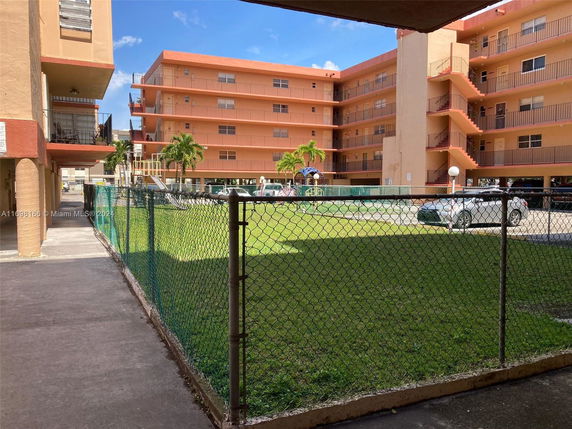 Outdoor courtyard with playground equipment adjacent to an apartment complex.