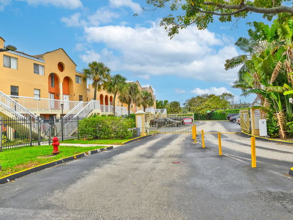 Front view of a multi-story residential building with gated entrance.