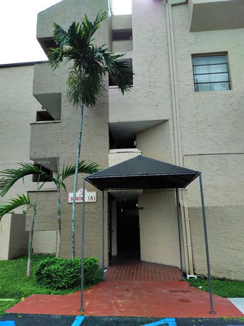 Front view of a multi-story building entrance with an awning.