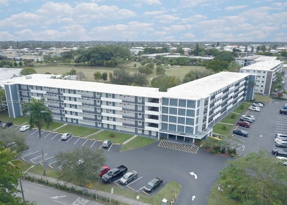 Front view of a multi-story residential building with a parking lot.