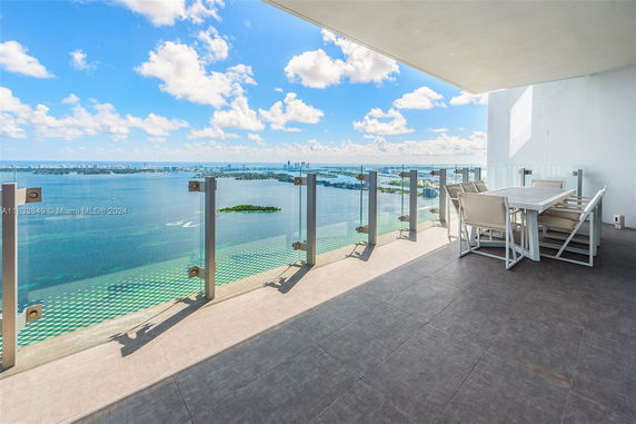 Wide-angle rooftop view overlooking a body of water and distant city skyline.