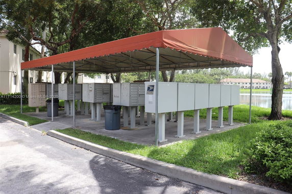 Covered outdoor mailboxes with red canopy.