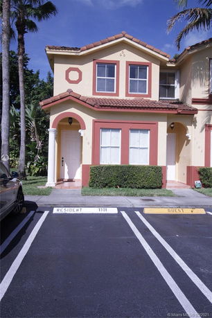 Front view of a two-story house with a designated parking space.