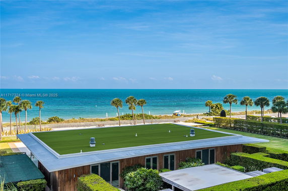 Building with a flat rooftop featuring greenery, situated near the ocean.