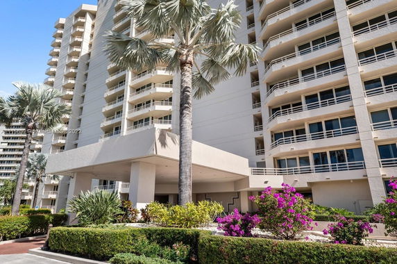 Front view of a modern multi-story residential building with balconies.