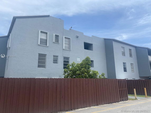 Front view of a multi-story building with a flat roof and multiple windows.