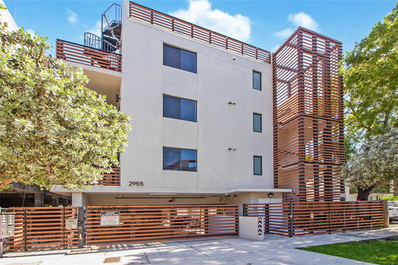 Front view of a multi-story building with a modern facade and wooden accents.