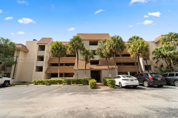 Front view of a multi-story building with parking area.