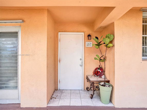 Front view of a house entrance with a small porch, door, and decorative items.