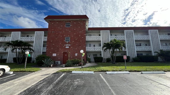 Front view of a multi-story brick building with balconies.