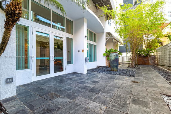 Front view of a modern building with large glass doors and windows.