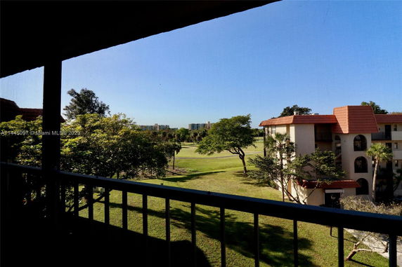 View from a building showing surrounding grassy areas and distant buildings.