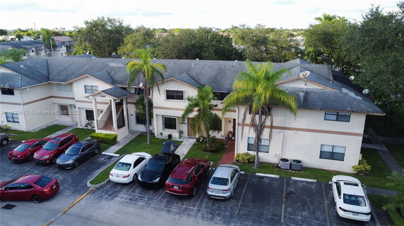 Front view of a two-story residential building with a parking area.