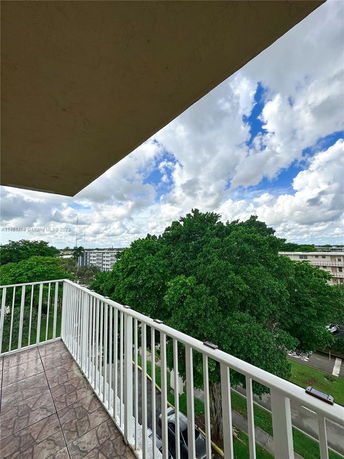 View from a balcony overlooking trees and buildings.