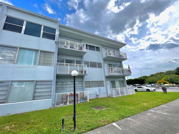 Front view of a three-story apartment building with balconies.