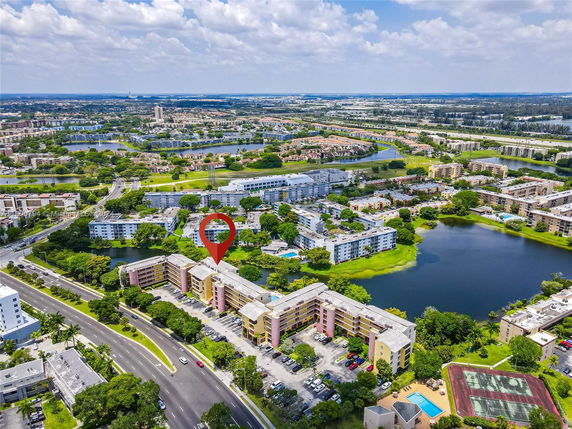 Aerial view of a residential area with multiple apartment buildings, roads, and a nearby water body.