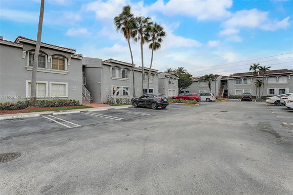 Outdoor parking area in front of a two-story residential building.