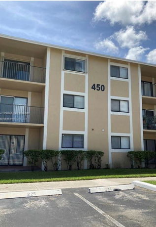Front view of a three-story residential building with balconies and numbered 450.