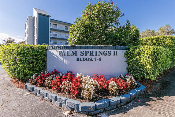 Front view of a multi-story building with a sign labeled 'Palm Springs II Bldgs. 7-8'.
