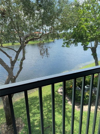 View from a balcony overlooking a lake and trees.