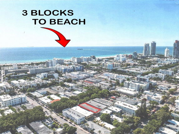 Aerial view of a coastal cityscape with buildings and the ocean in the background.