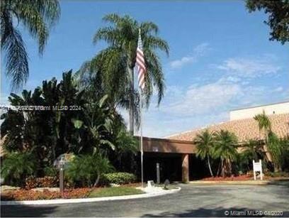 Front view of a building surrounded by palm trees.