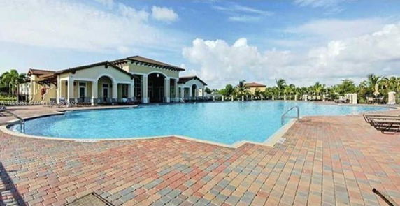 Large outdoor swimming pool area with adjacent building.
