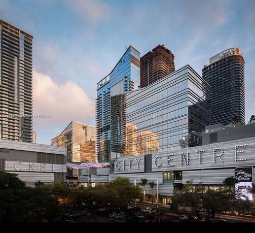 Front view of a modern, multi-story commercial building with glass facades and signage indicating 'City Centre'.
