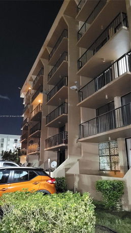Night view of a multi-story residential building with balconies.