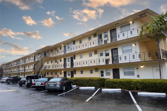 Front view of a multi-story apartment building with balconies.