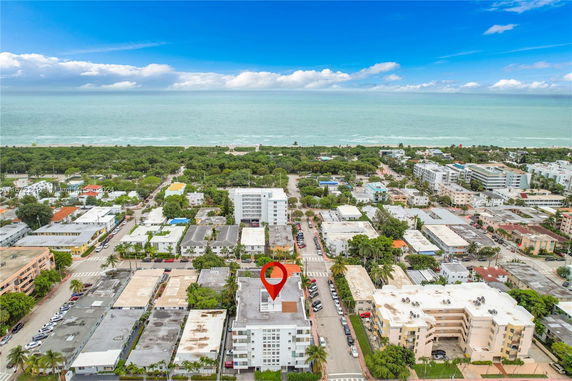 Aerial view of a seaside residential area with buildings and roads near the ocean.