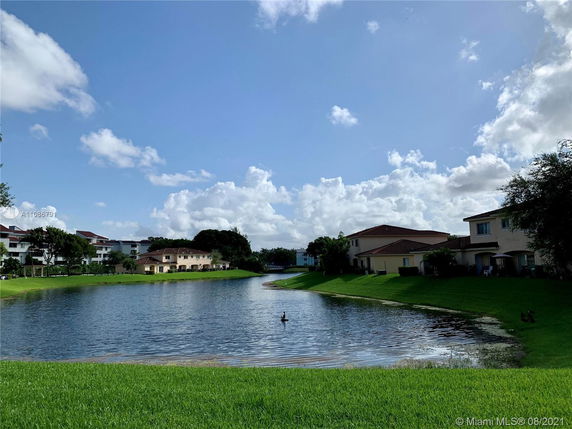 View of houses and a body of water with a grassy area.